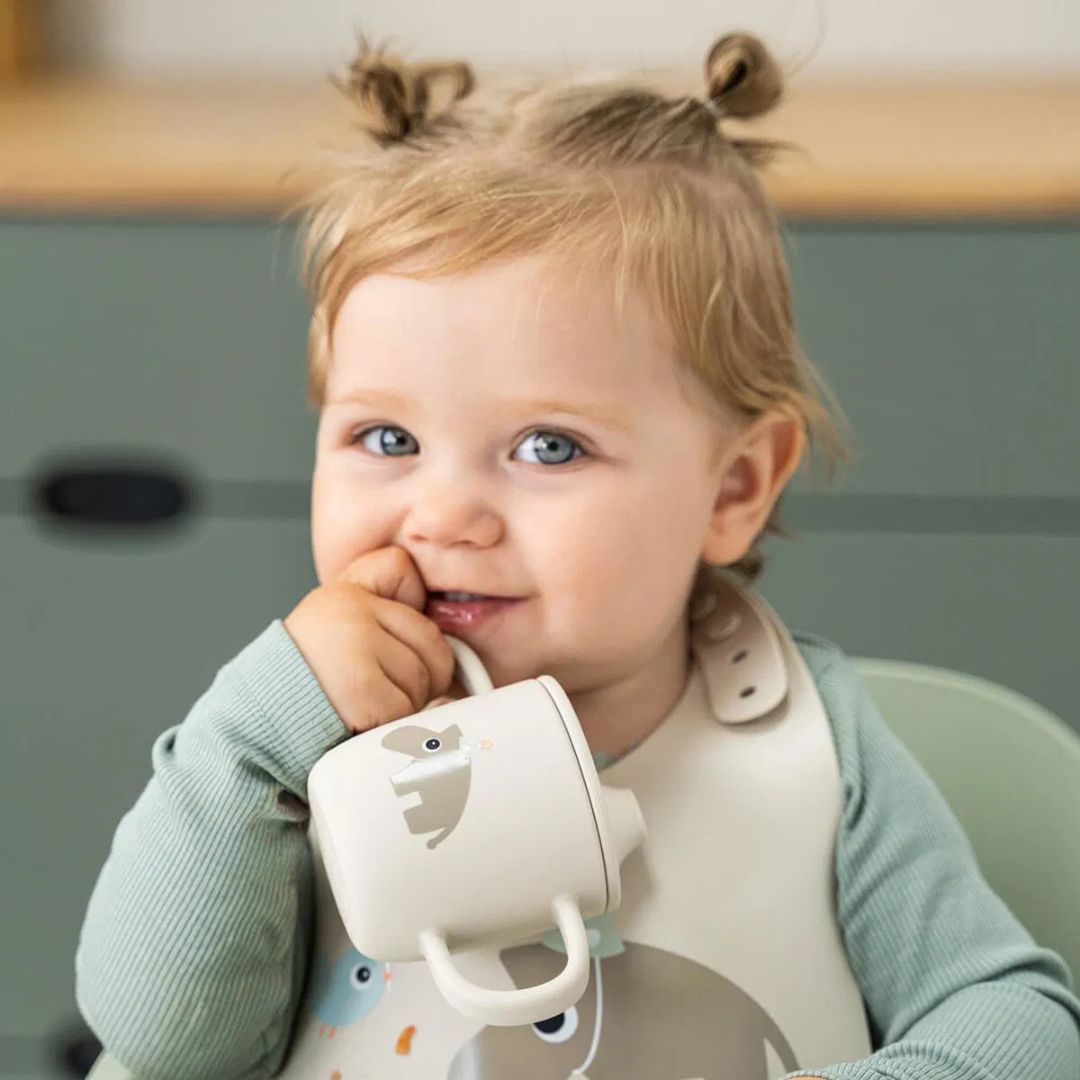 Done by Deer® Silikonski lonček s pokrovčkom in ročaji Celebration Sand Done by Deer